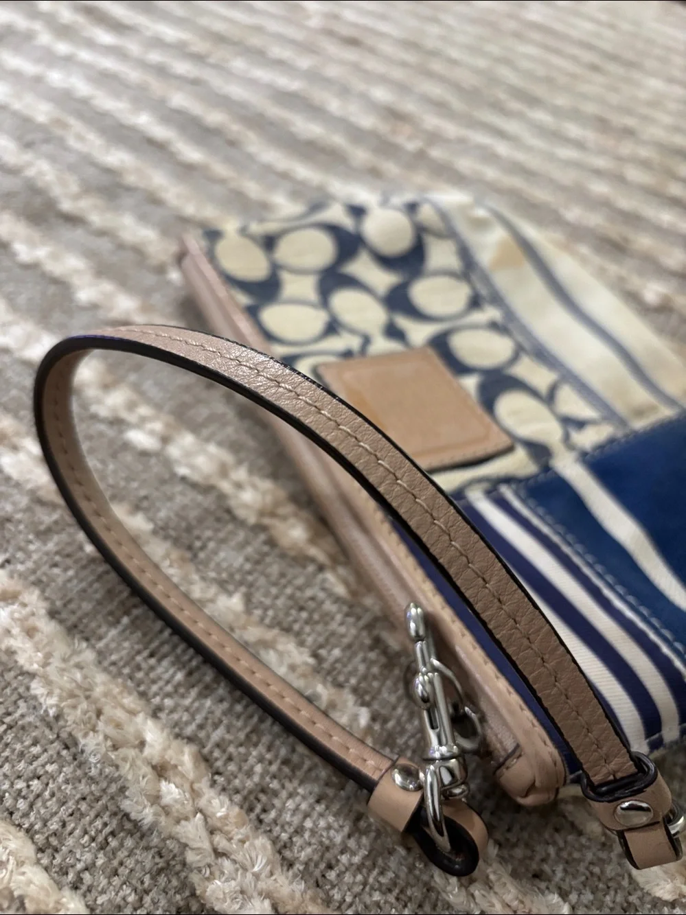 Coach wristlet featuring signature patchwork print in navy and cream
